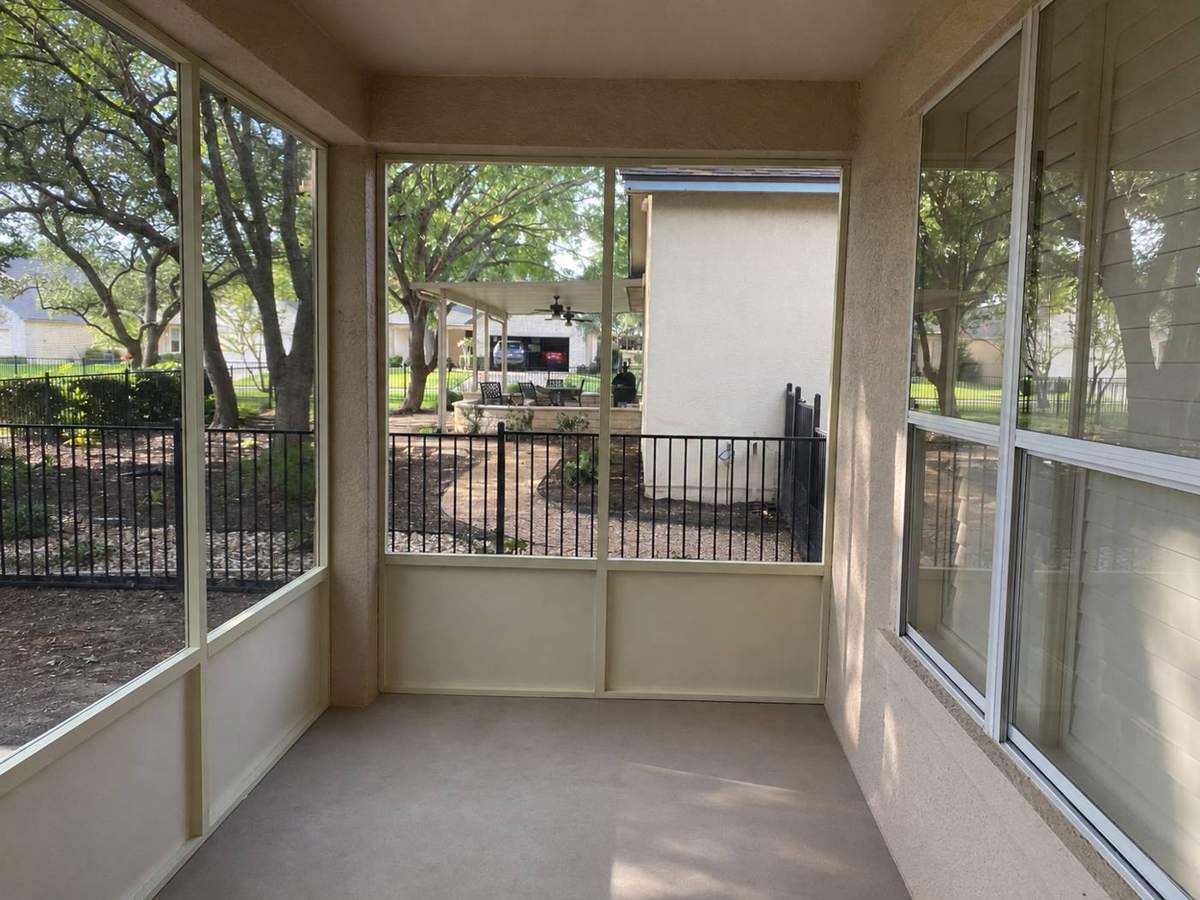 Jacobs screened porch interior corner with iron fence beyond