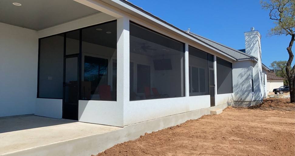 Modern white stucco home with full-height black screen walls