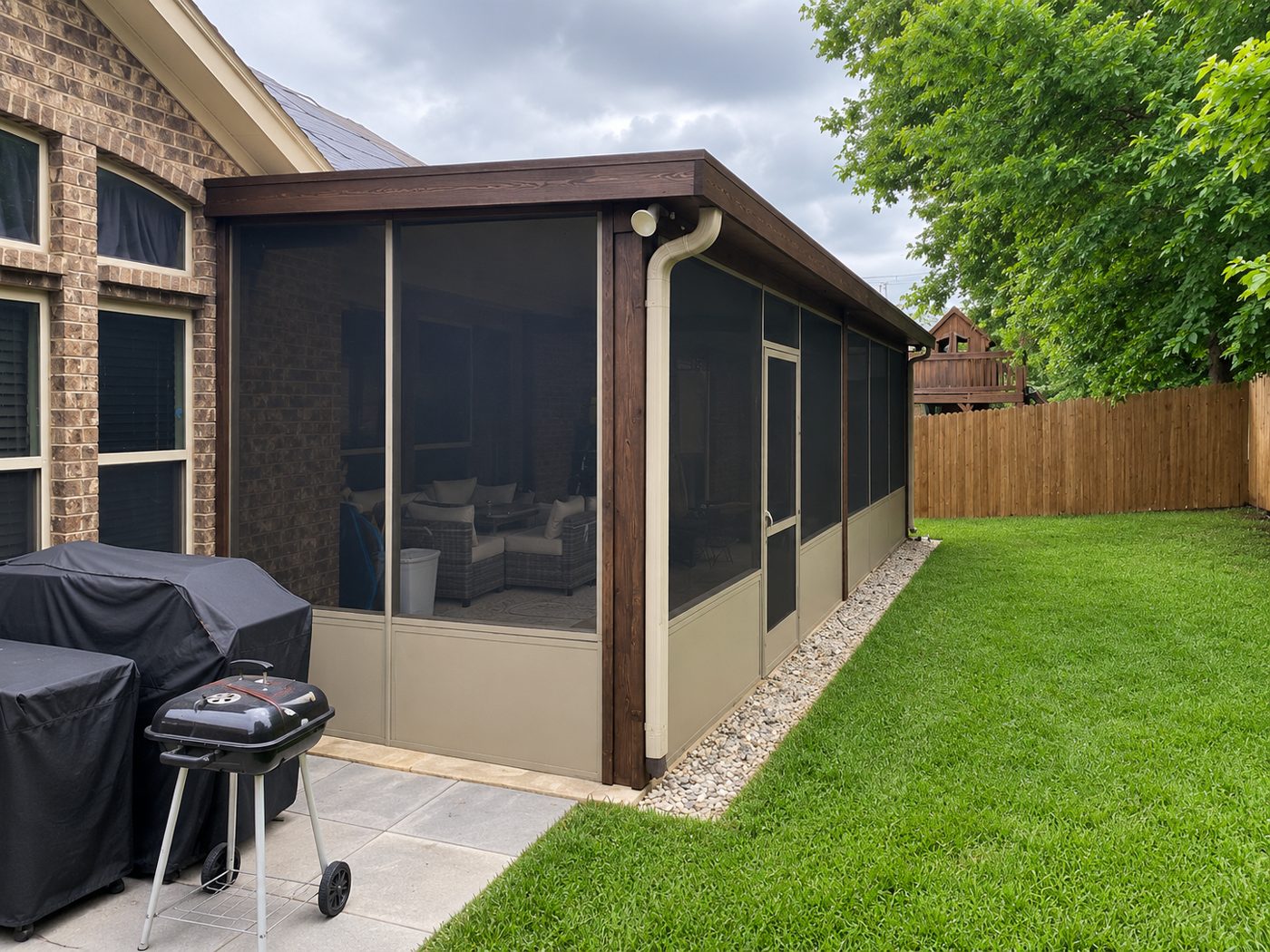 Screened porch with dark-stained wood wrap and tan kick panels